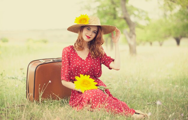 Redhead girl with sunflower at outdoor.