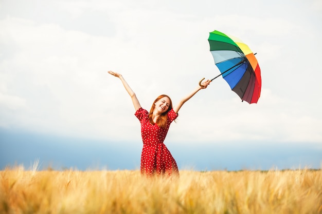Рыжая девушка с зонтом на поле
