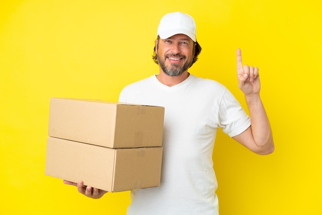 Redhead man over blue wall pointing to the side to present a product