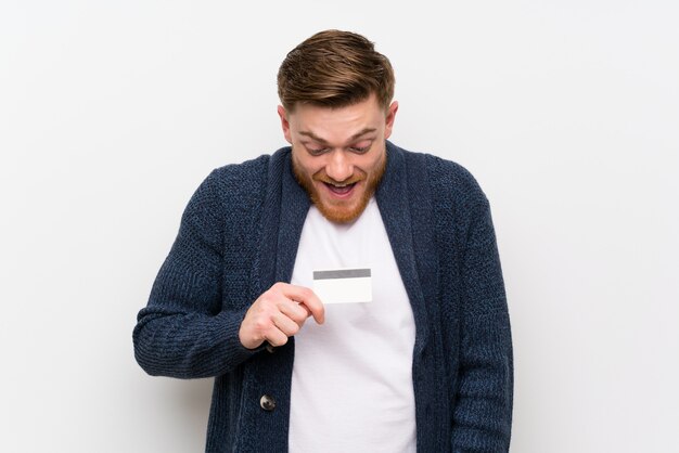 Uomo di redhead che tiene una carta di credito