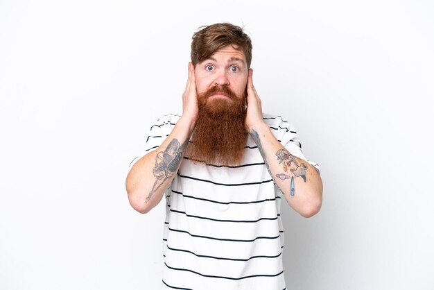 Redhead man with beard isolated on white background frustrated and covering ears