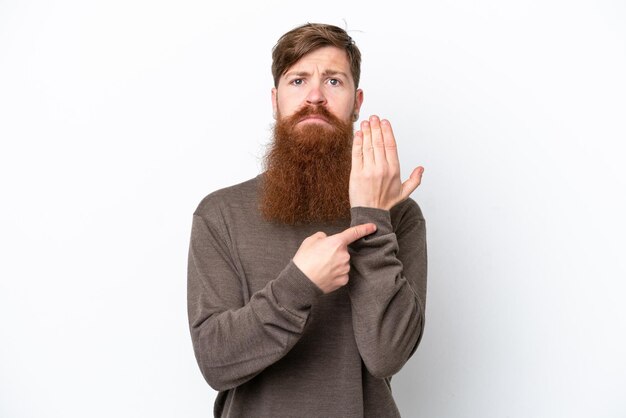 Foto uomo rosso con barba isolato su sfondo bianco che fa il gesto di essere in ritardo