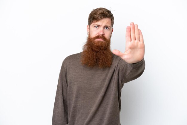 Redhead man with beard isolated on white background making stop gesture