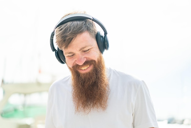 Redhead man with beard listening music