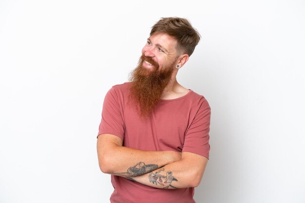 Redhead man with long beard isolated on white background looking to the side and smiling