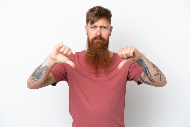 Redhead man with long beard isolated on white background showing thumb down with two hands