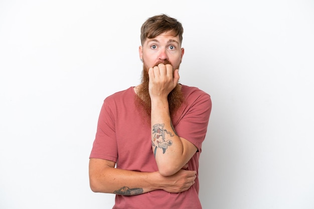 Redhead man with long beard isolated on white background surprised and shocked while looking right