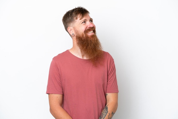 Redhead man with long beard isolated on white background thinking an idea while looking up