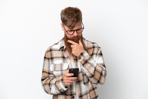 Redhead man with long beard isolated on white background thinking and sending a message