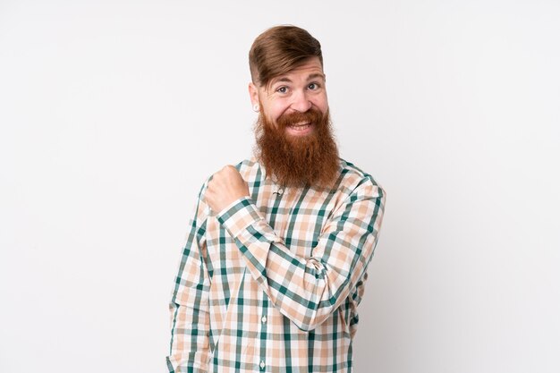 Redhead man with long beard over isolated white celebrating a victory