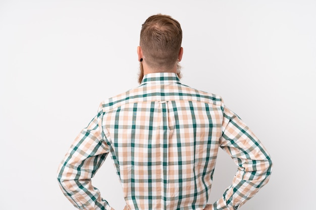 Photo redhead man with long beard over isolated white wall in back position