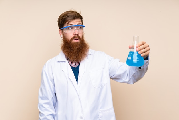 Redhead man with long beard with a scientific test tube