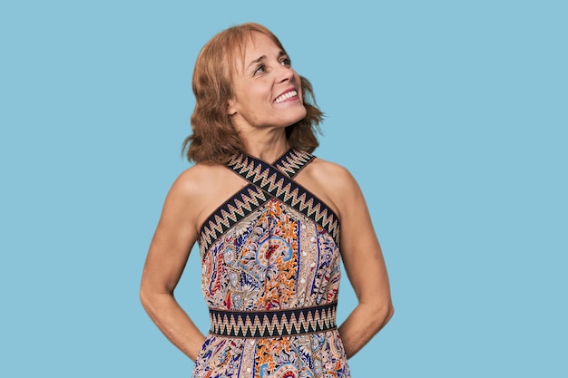 Redhead midaged Caucasian woman in studio relaxed and happy laughing neck stretched showing teeth