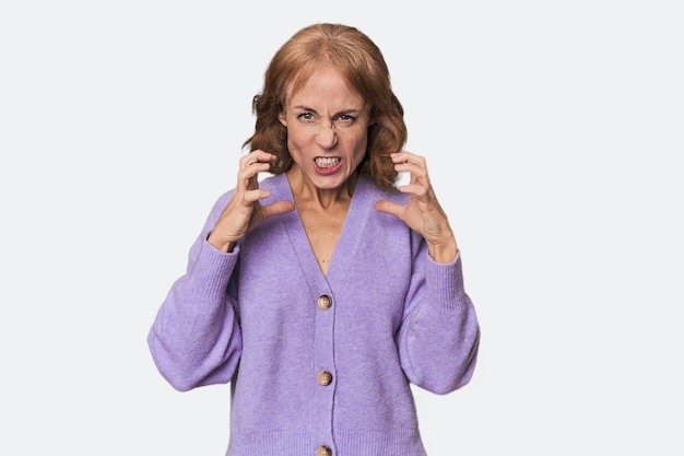 Photo redhead midaged caucasian woman in studio upset screaming with tense hands