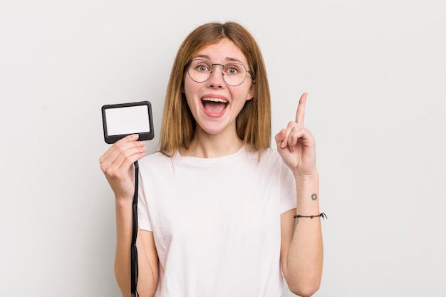 Redhead pretty girl feeling like a happy and excited genius after realizing an idea vip pass id concept