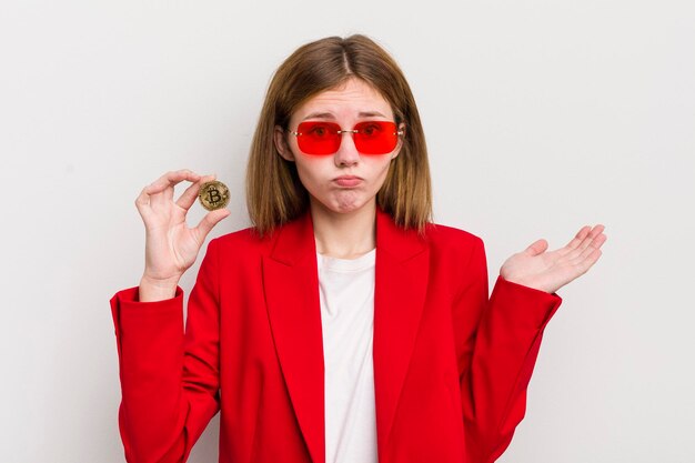 Redhead pretty girl feeling puzzled and confused and doubting bitcoin concept