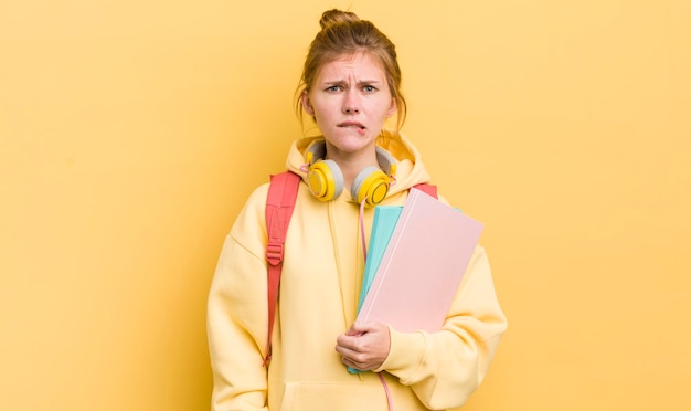 Redhead pretty girl looking puzzled and confused student concept