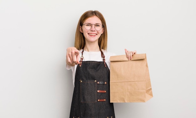 Redhead pretty girl pointing at camera choosing you take away employee