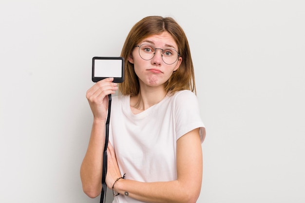 Redhead pretty girl shrugging feeling confused and uncertain vip pass id concept