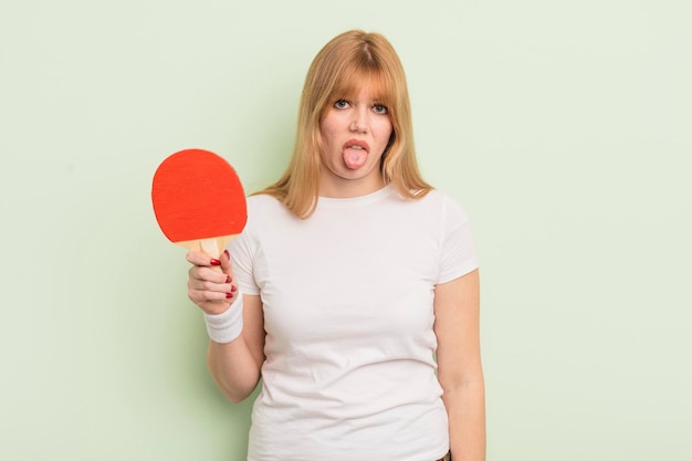 Redhead pretty woman feeling disgusted and irritated and tongue out ping pong concept