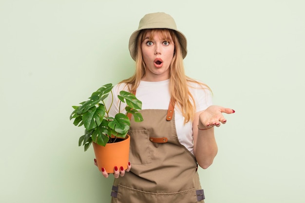 Redhead pretty woman feeling extremely shocked and surprised. gardener concept