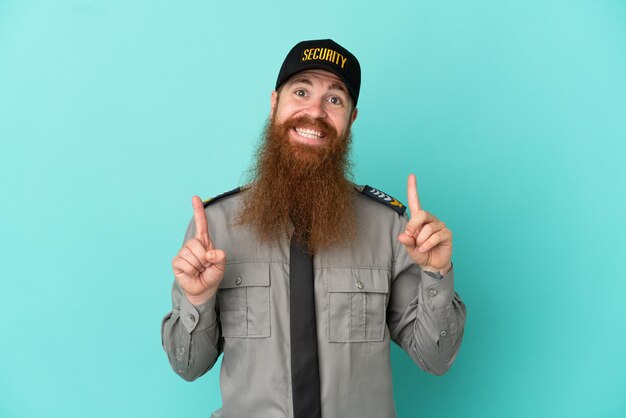 Photo redhead security man isolated on white background pointing up a great idea