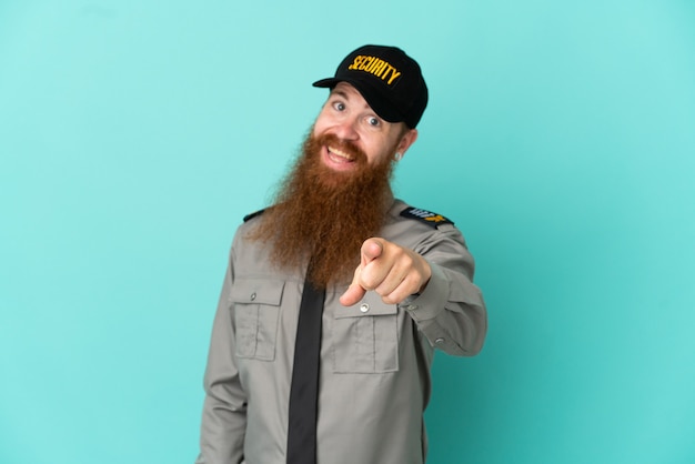Redhead security man isolated on white background points finger at you with a confident expression