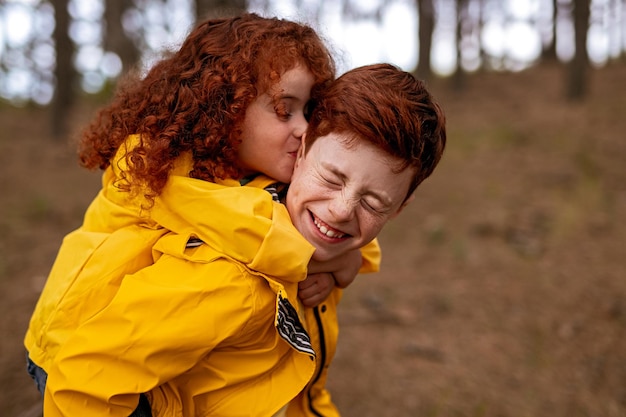 Redhead siblings having fun in autumn forest