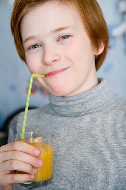 Redhead teen drinking juice