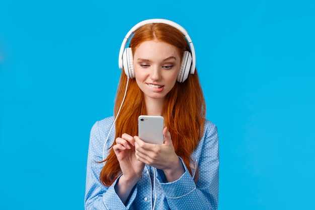 Redhead vrouw met behulp van een koptelefoon