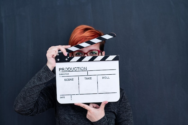 映画クラッパーシネマコンセプトを保持している黒い黒板に赤毛の女性