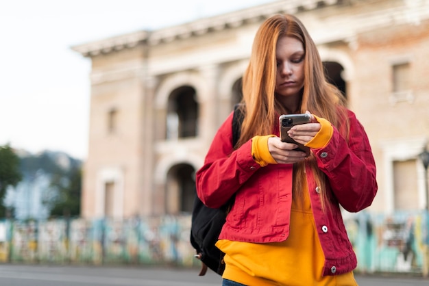 彼女の電話をチェックしている赤毛の女性