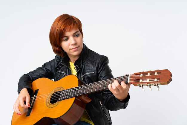 赤毛の女性がギターを弾く