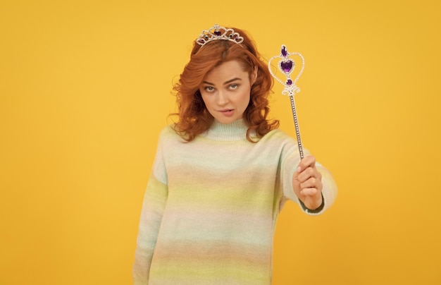 Redhead woman in queen crown with magic wand magic