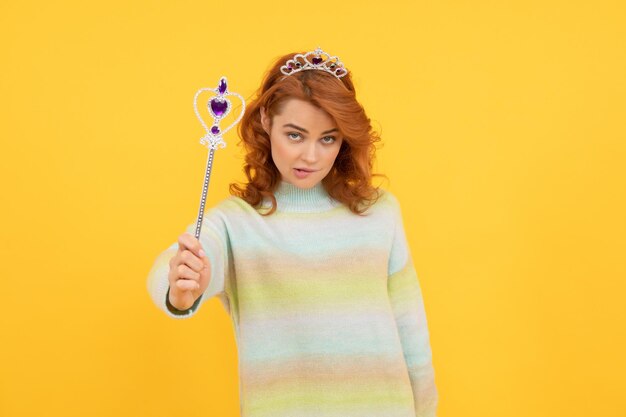 Redhead woman in queen crown with magic wand, magic.