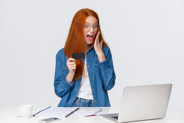 redhead woman seeing something awesome on screen laptop