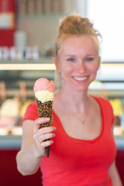 Redhead woman showing an ice cream to the camera