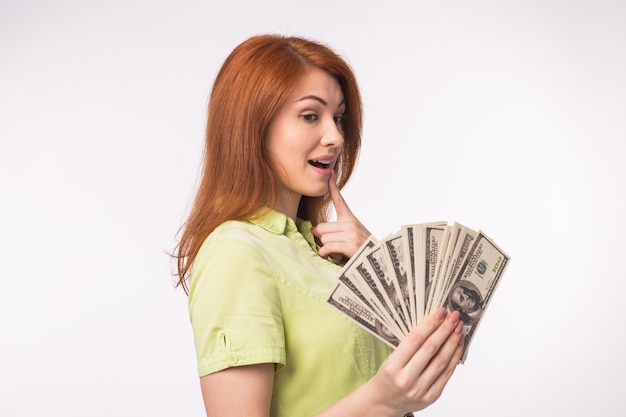 Redhead woman with money on white background
