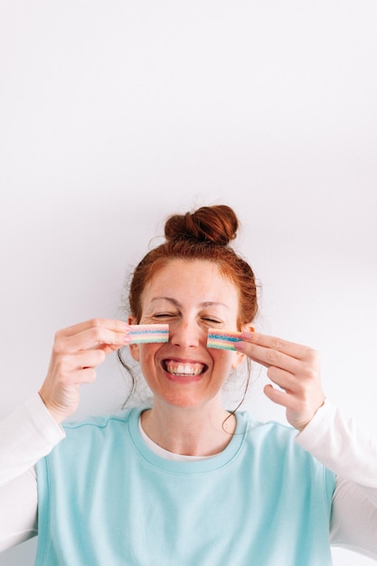 Redhead woman with rainbow candy freckles on her face white background