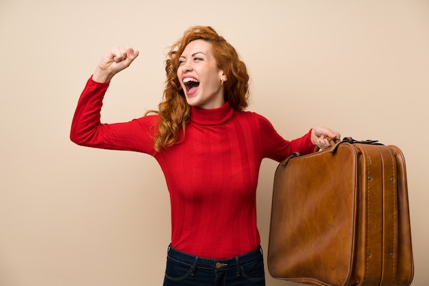 Redhead woman with turtleneck sweater holding a vintage briefcase