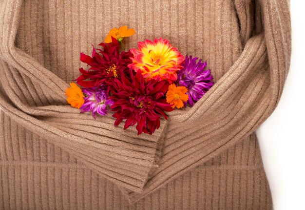 Redhead woolen sweater and autumn flowers on white background