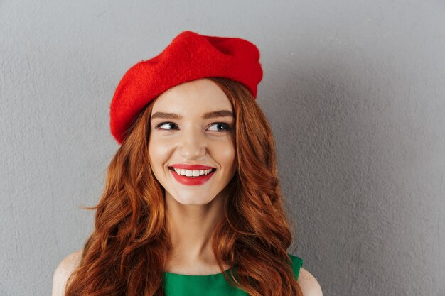 Redhead young cheerful lady looking aside.