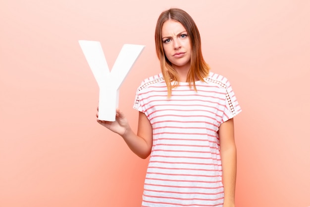 redhead young girl in a T-shirt holding the letter y