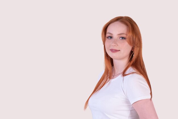 Redhead young woman on a light background