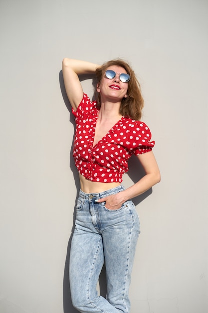 Redhead young woman in red blouse in polka-dot pattern