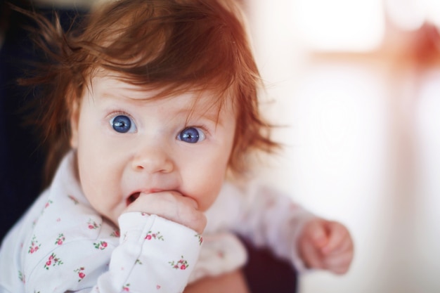 Redheaded baby with blue eyes looking at camera