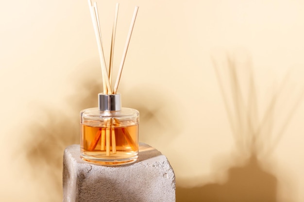 Reed diffuser bottle on the podium Incense sticks for the home with a floral scent with hard shadows The concept of ecofriendly fragrance for the home