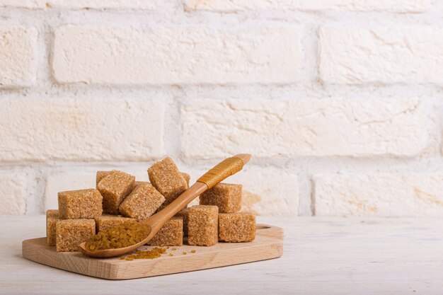 Reed sahao a cubetti su una tavola di legno e un cucchiaio di zucchero con la sabbia