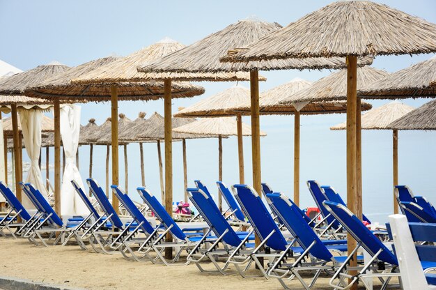 Reed umbrellas and deck chairs at the beach