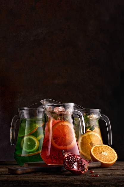 Foto reeks kleurrijke limonades in kannen. op donkere achtergrond